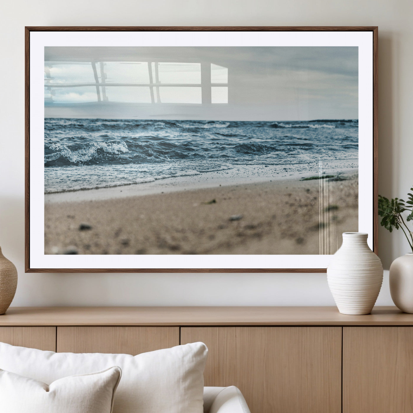 A moody ocean scene with gentle waves washing onto a sandy beach under a cloudy sky, creating a peaceful and coastal atmosphere.