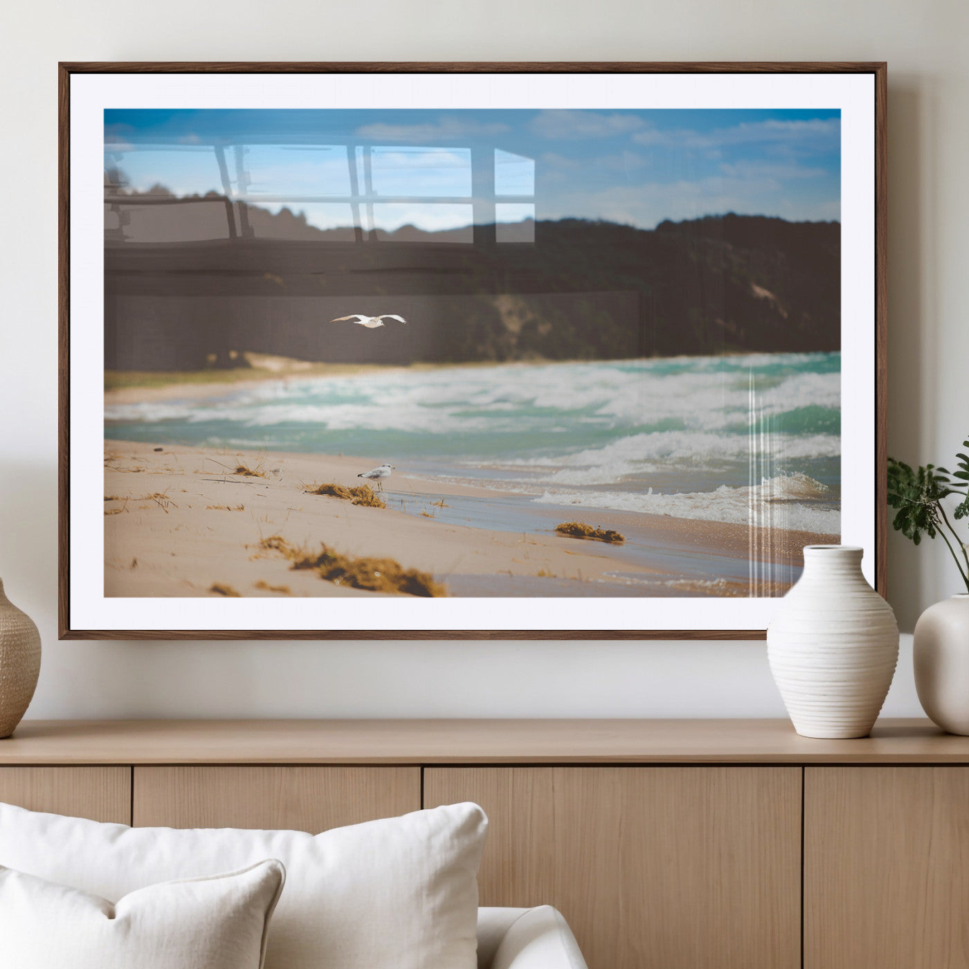 Serene beach scene with gentle ocean waves, sandy shore, and a seagull flying under a blue sky, perfect for coastal and nature-inspired decor.