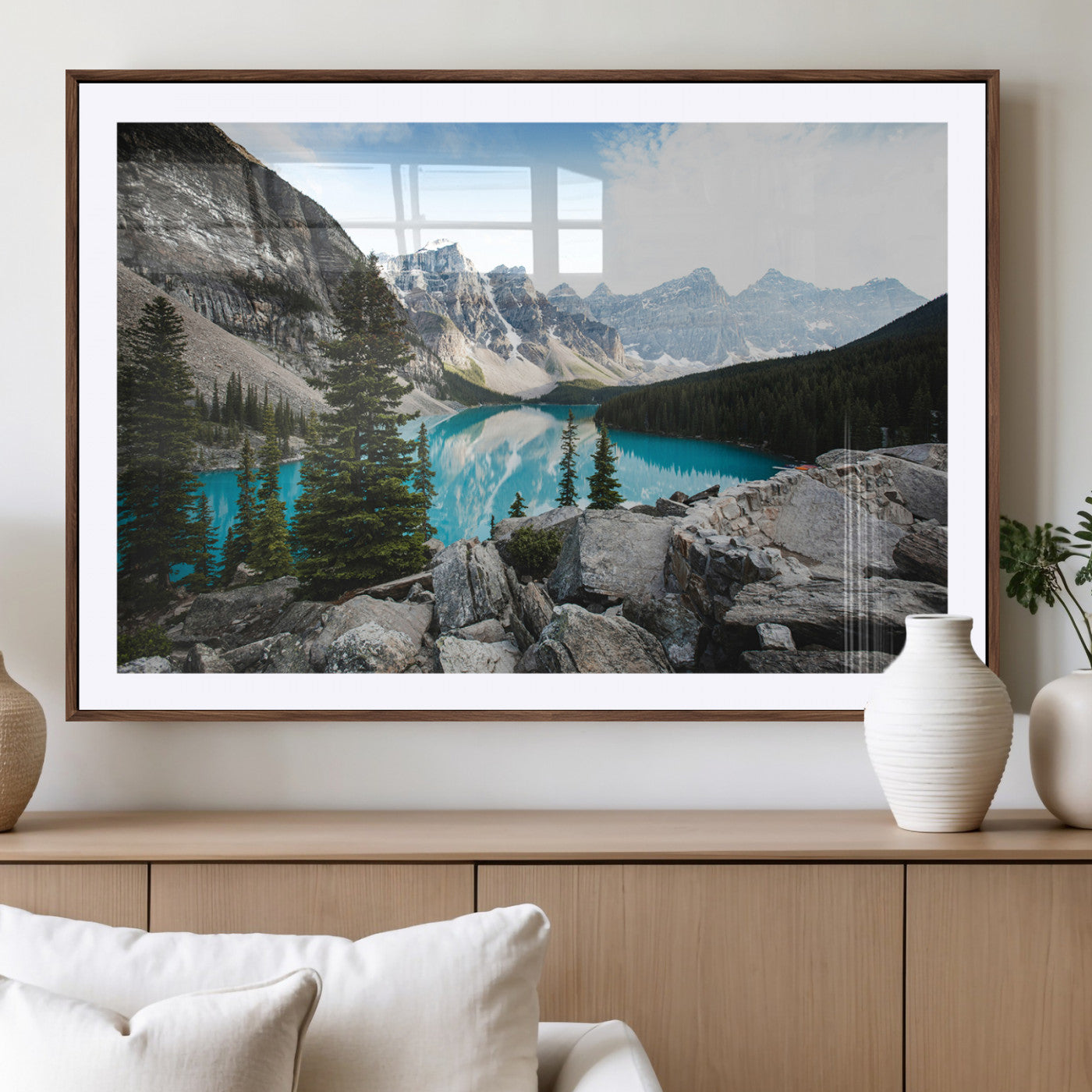 Stunning view of Moraine Lake with turquoise waters reflecting snow-capped mountains and evergreen trees, creating a peaceful alpine decor.