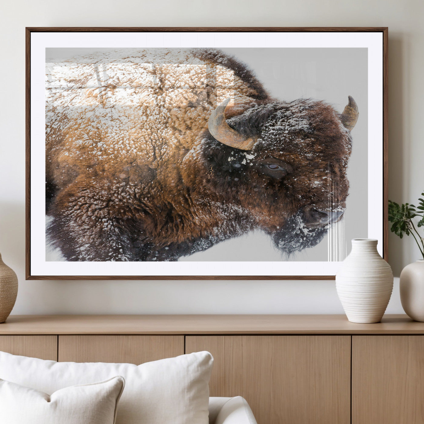 Close-up photograph of a bison covered in snow, highlighting its thick fur and powerful presence, set against a white winter backdrop, ideal for rustic decor.