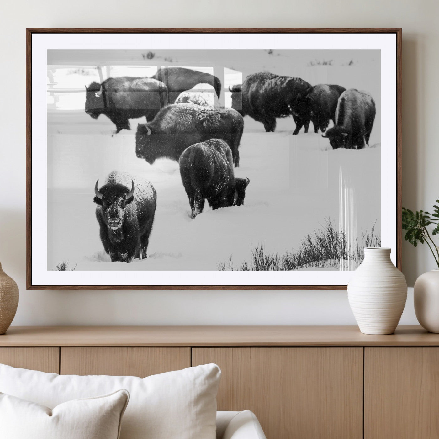 Black and white photograph of a bison herd in a snowy landscape, with snow-covered fur and a rugged wilderness setting, perfect for rustic lodge decor.