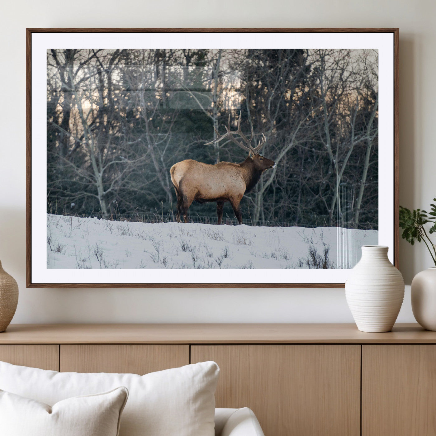 A majestic elk with large antlers standing in a snowy field against a winter forest backdrop, perfect for rustic and wildlife-themed home decor.