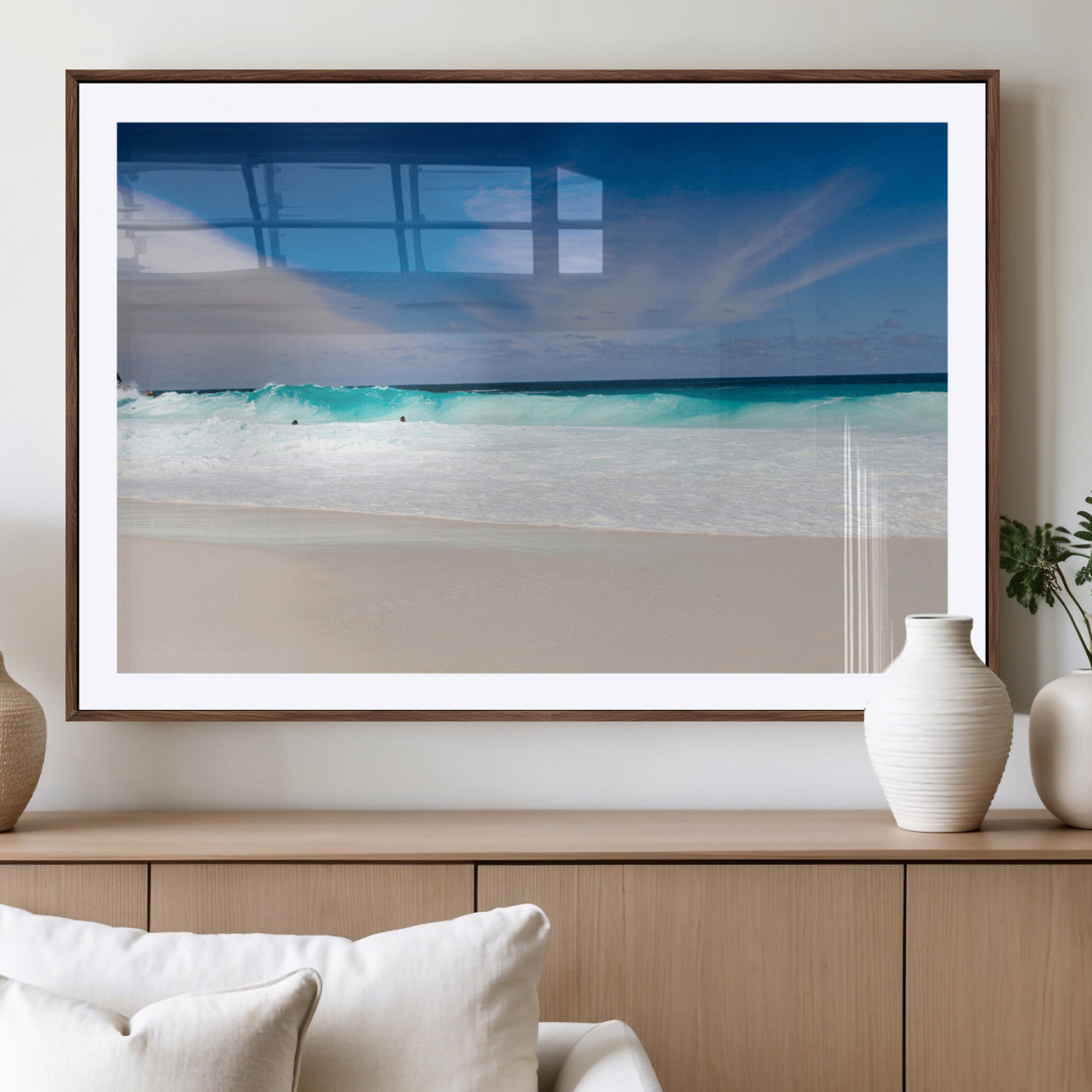 Turquoise waves crash onto a pristine white sand beach under a vivid blue sky with wispy clouds, creating a peaceful and refreshing coastal scene.