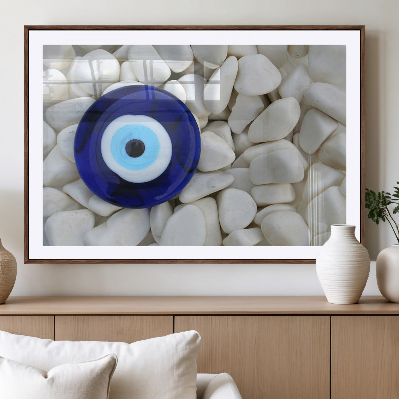 A close-up of a blue evil eye charm placed on white pebbles, symbolizing protection and good luck.