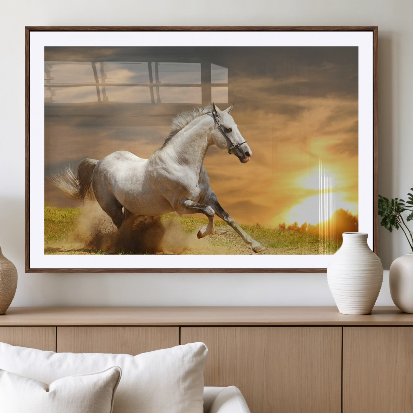 A powerful white horse galloping through the field at sunset, with the golden light illuminating its mane and the vibrant sky in the background.