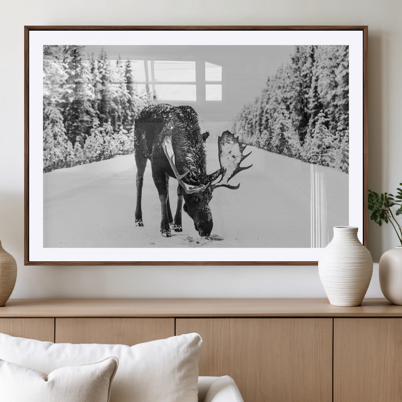 A majestic moose grazing in the snow-covered wilderness, surrounded by snow-covered trees, creating a peaceful winter scene.