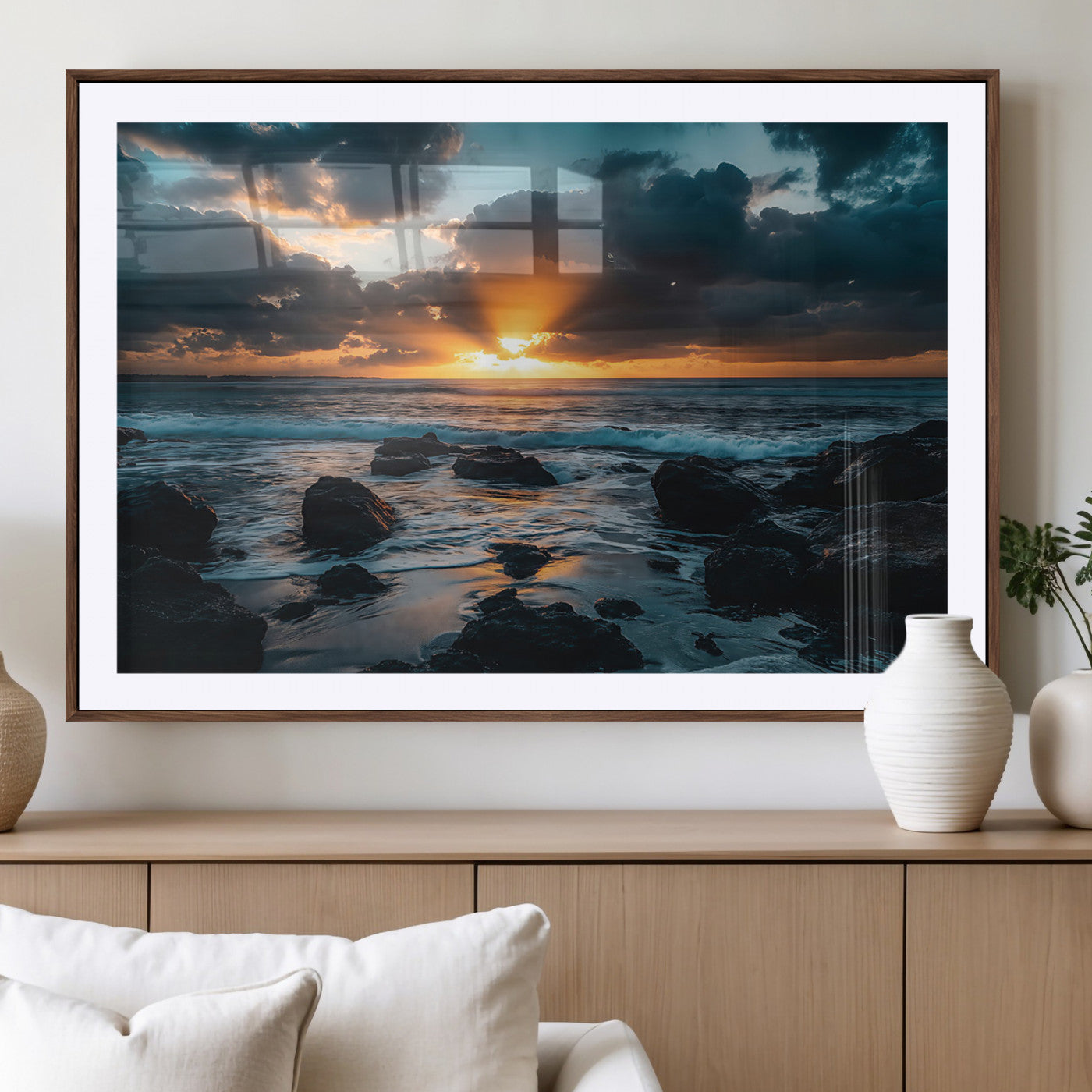 An awe-inspiring sunset over the ocean with rays of light piercing through dramatic clouds, creating a beautiful seascape with rocks in the foreground.
