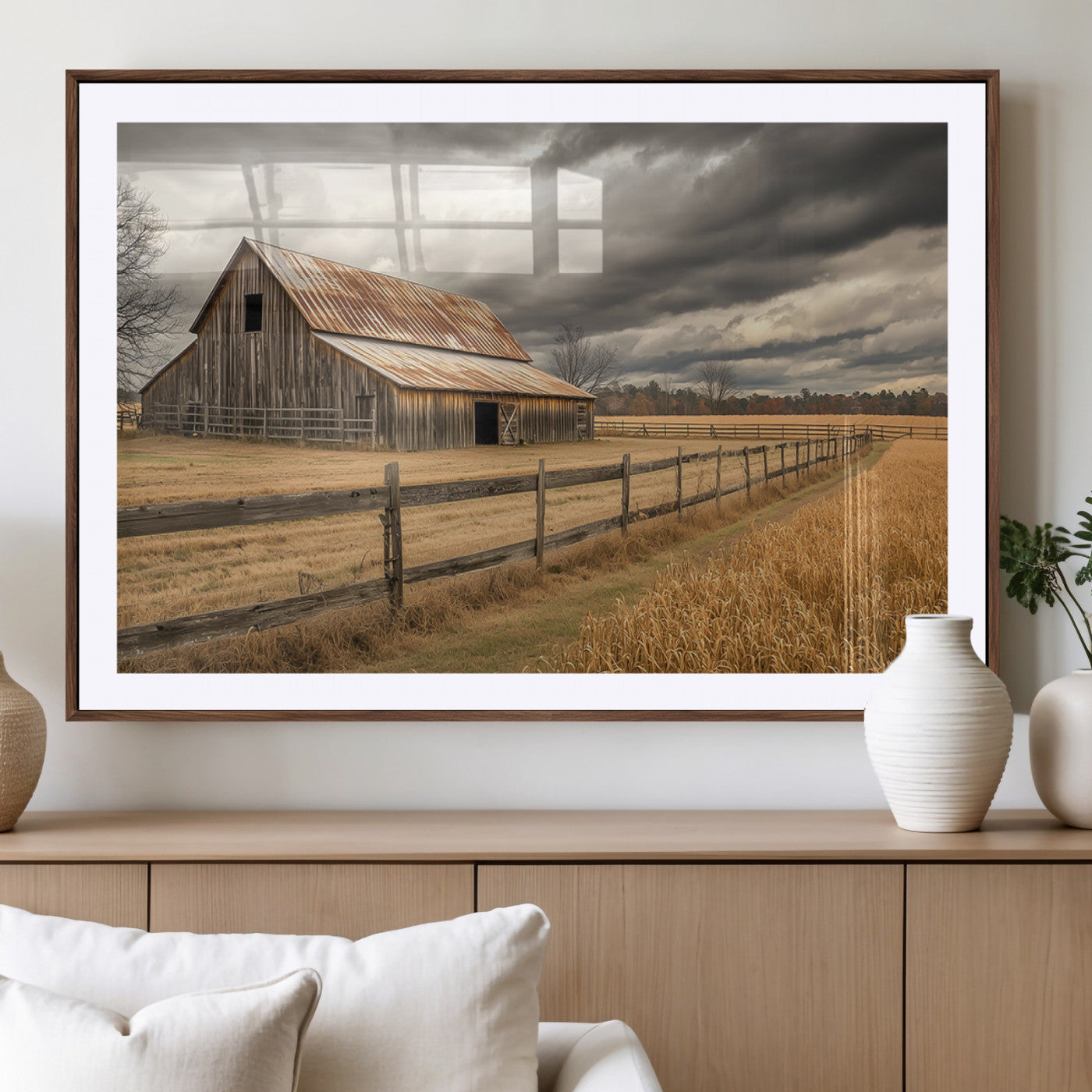 "Rustic barn with a weathered metal roof, surrounded by a wooden fence and golden fields under an overcast sky with dramatic clouds."