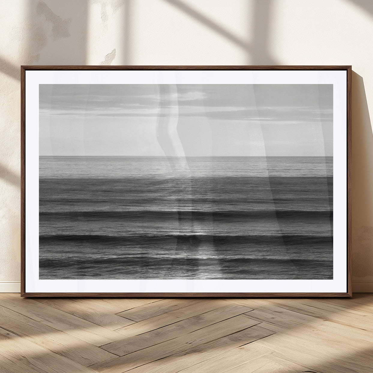 Minimalist black and white ocean view with layered waves reflecting sunlight, evoking a sense of calm and coastal serenity.
