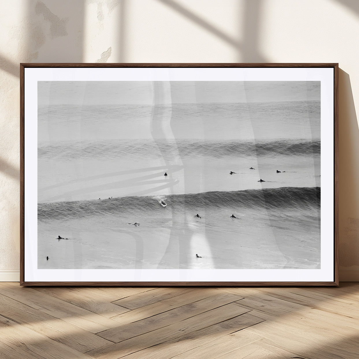 A monochrome photograph of swimmers gliding through gentle ocean waves, evoking a sense of calm and movement.