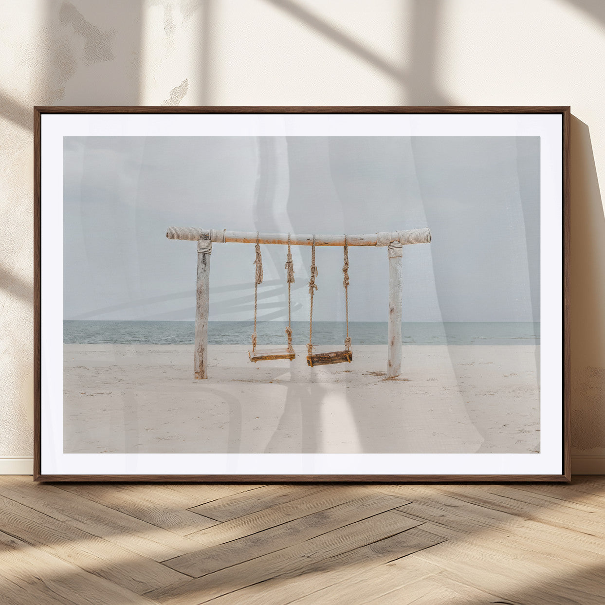 A rustic wooden beach swing stands on a serene sandy shore with an ocean horizon in the background, creating a tranquil and dreamy coastal escape.