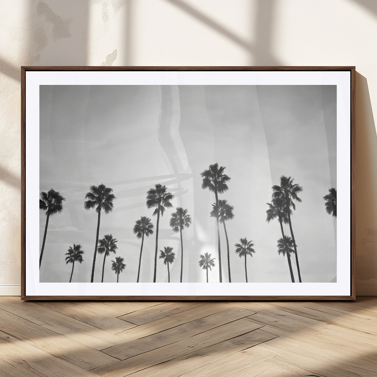 A black and white minimalist scene featuring tall palm trees silhouetted against a bright sky, creating a dreamy and timeless tropical aesthetic.