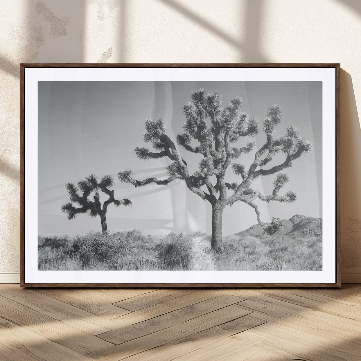 Two Joshua trees in a black and white desert landscape with distant hills, ideal for boho or rustic interior wall styling.