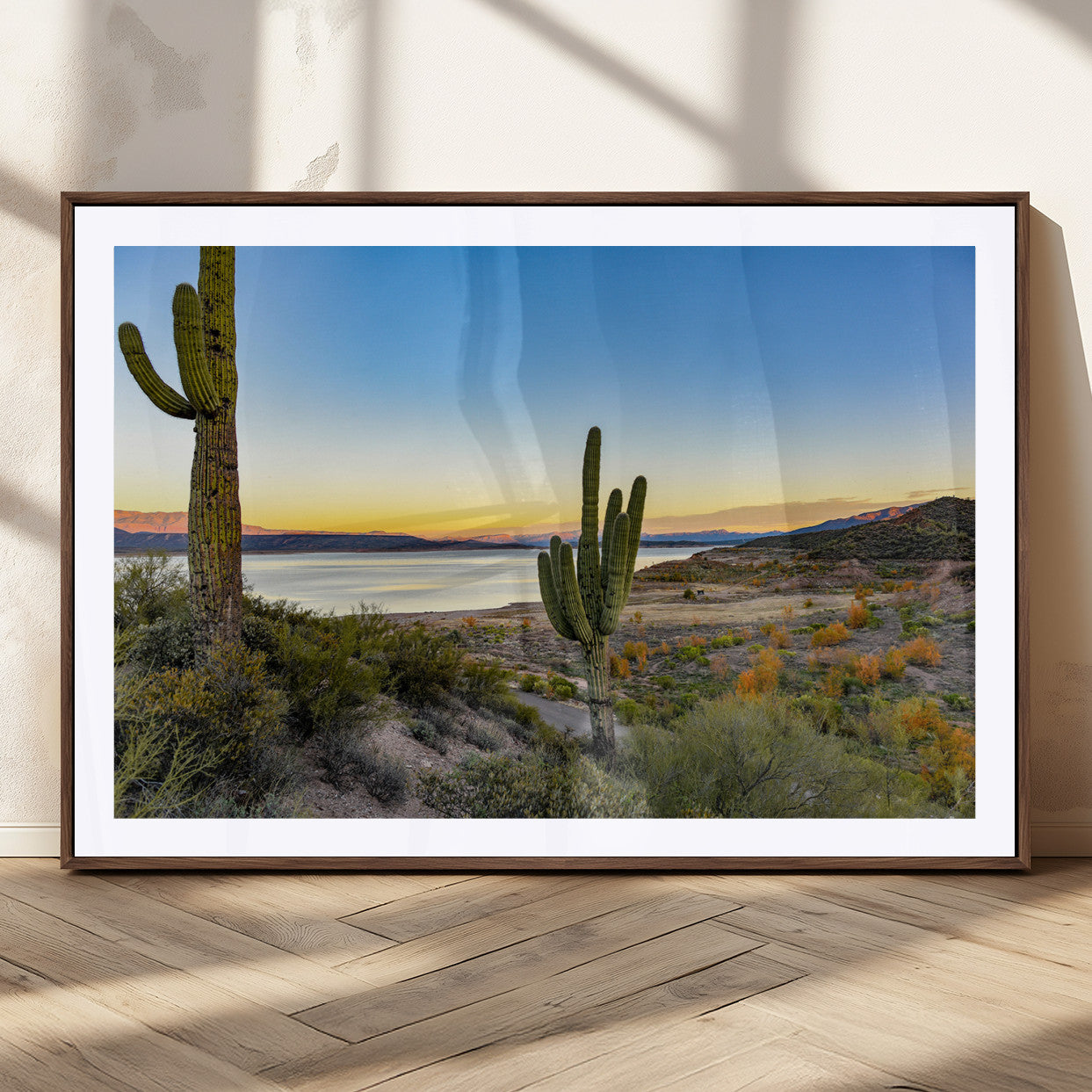 Desert landscape with saguaro cacti and lake at sunset, featuring vibrant sky and hills, ideal for Southwestern or rustic wall decor.