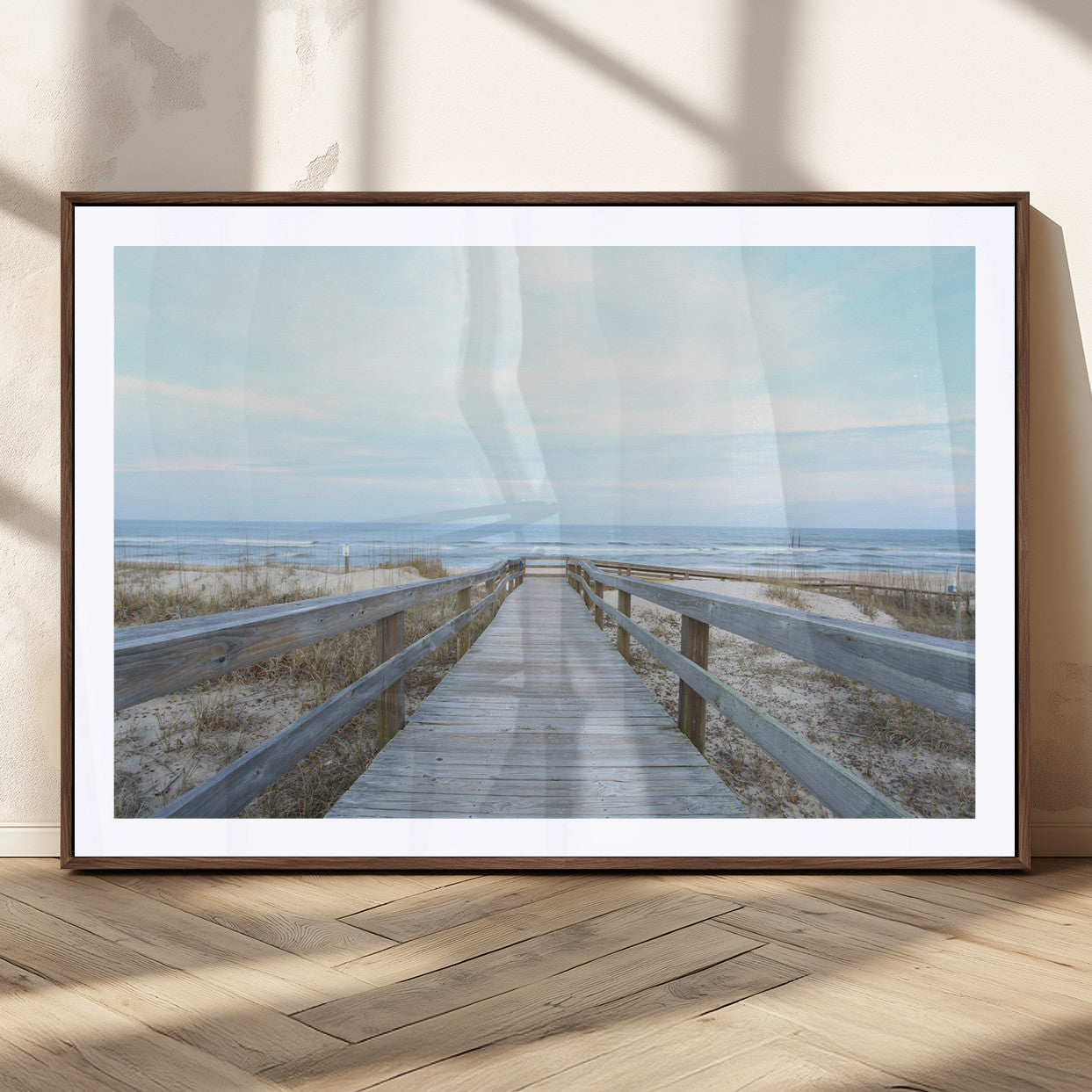 Wooden boardwalk leading to a peaceful beach with gentle ocean waves under a soft pastel sky, perfect for coastal and nautical home decor.