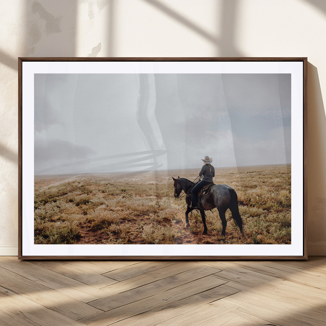 A lone cowboy riding horseback across an open prairie under a vast sky, capturing the rugged and timeless spirit of the Western frontier.