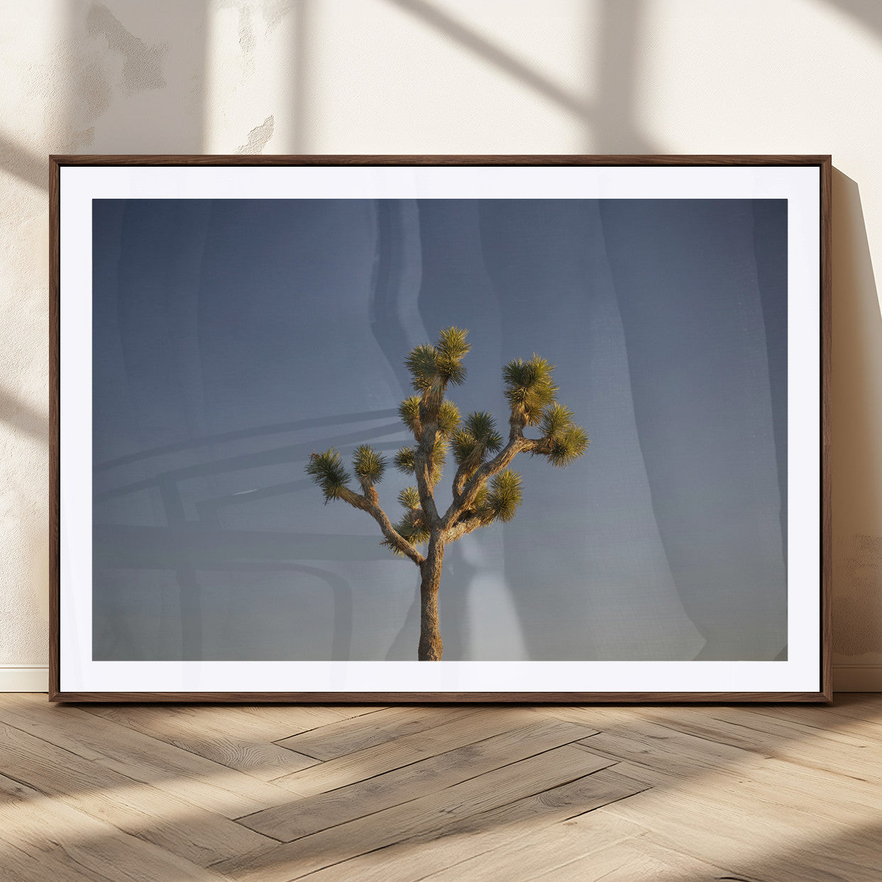 A lone Joshua Tree standing against a deep blue sky, capturing the serene and rugged beauty of the Southwestern desert landscape.