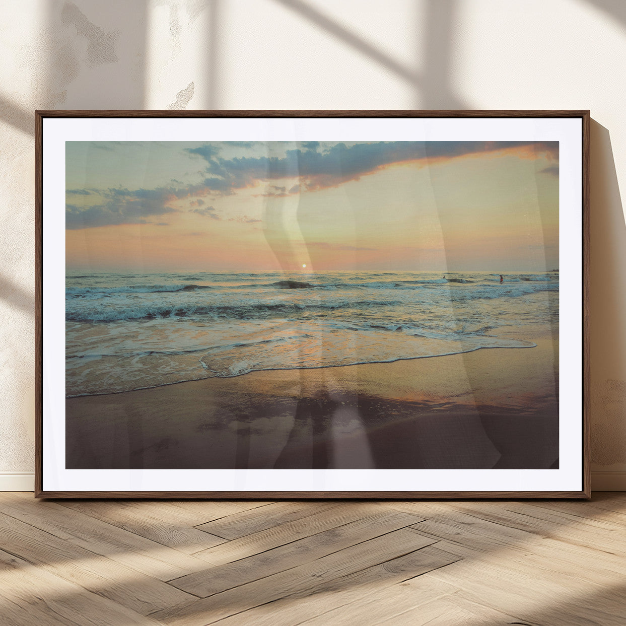 Warm sunset over gentle ocean waves with pastel sky and reflections on wet sand, creating a calm and soothing beach ambiance.
