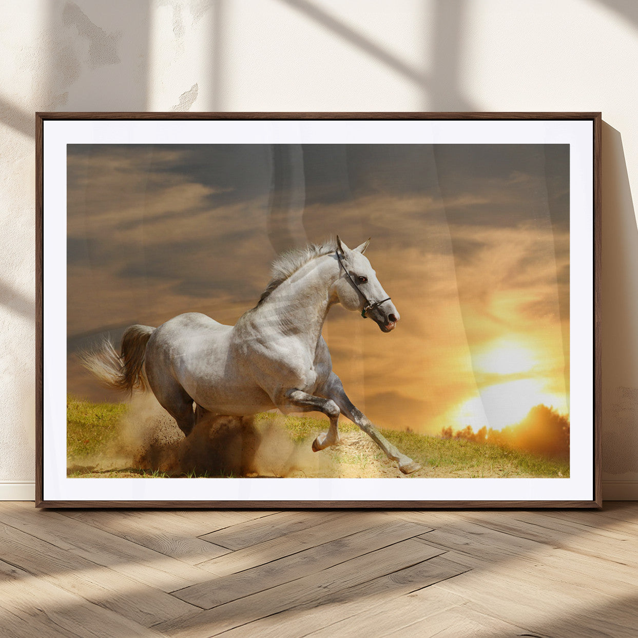 A powerful white horse galloping through the field at sunset, with the golden light illuminating its mane and the vibrant sky in the background.