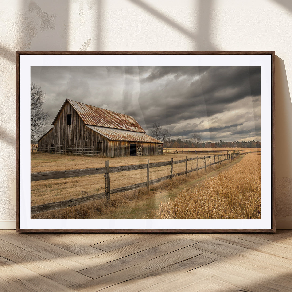 "Rustic barn with a weathered metal roof, surrounded by a wooden fence and golden fields under an overcast sky with dramatic clouds."