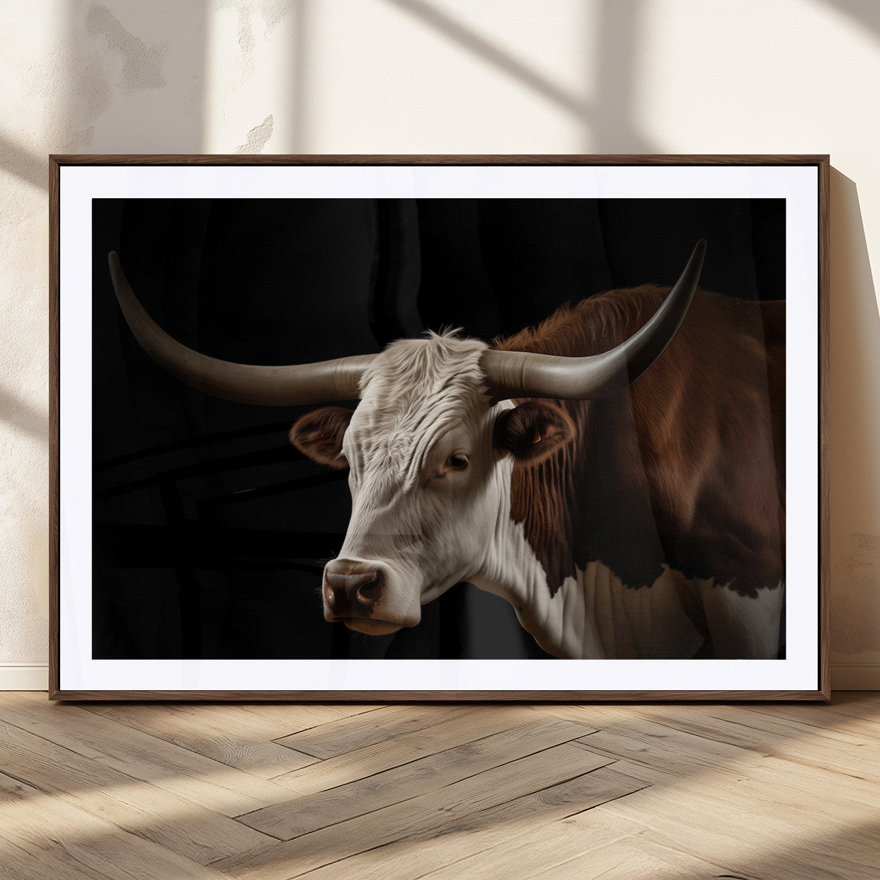 "Close-up of a brown and white longhorn cow with prominent curved horns against a black background."