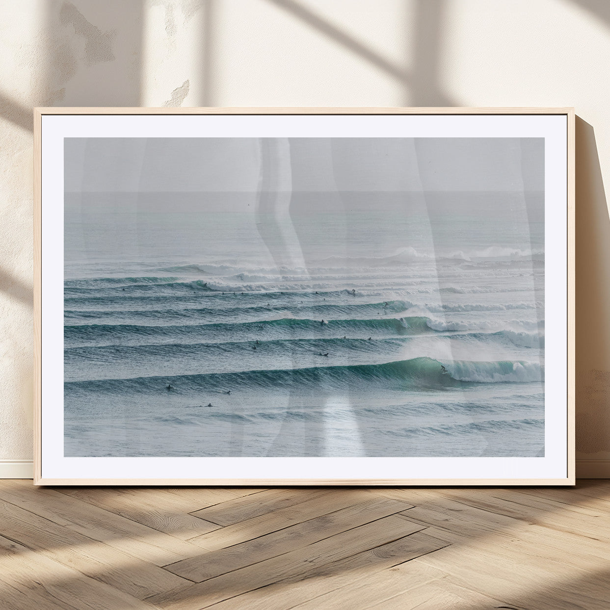 High-angle view of surfers lining up across layered ocean waves, ideal for minimal coastal or surf-inspired room decor.