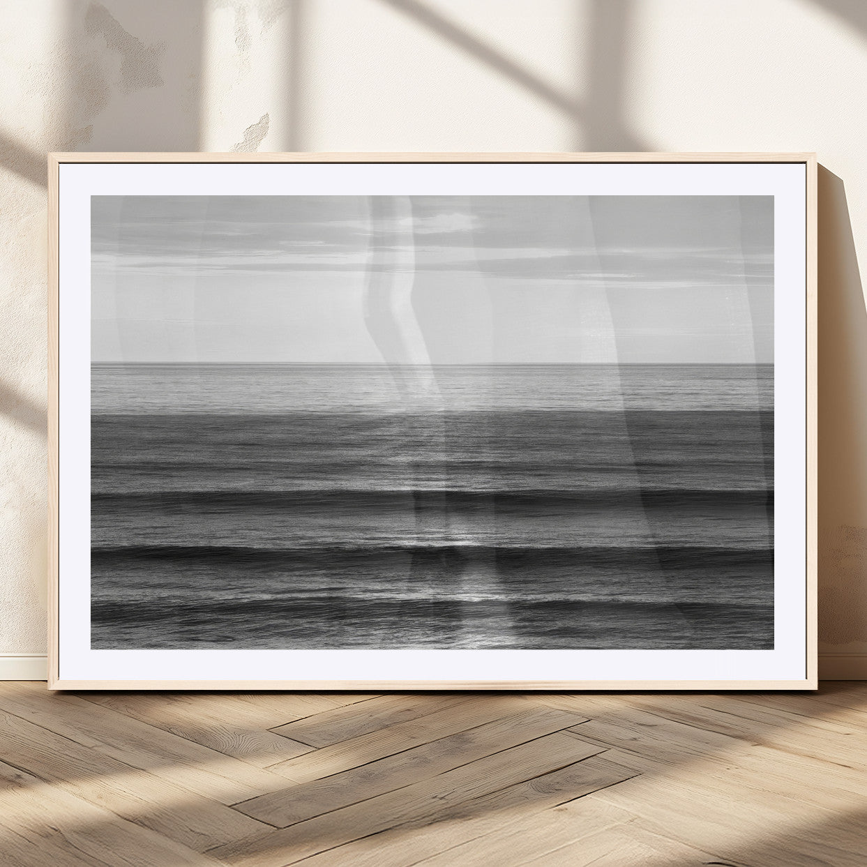 Minimalist black and white ocean view with layered waves reflecting sunlight, evoking a sense of calm and coastal serenity.