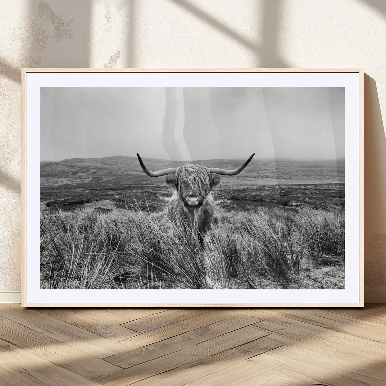 A black and white portrait of a Highland cow in a foggy Scottish countryside, capturing a rustic aesthetic and tranquil farm escape.