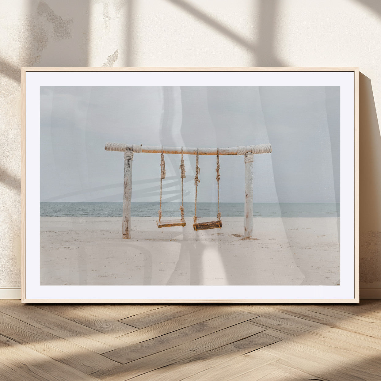 A rustic wooden beach swing stands on a serene sandy shore with an ocean horizon in the background, creating a tranquil and dreamy coastal escape.