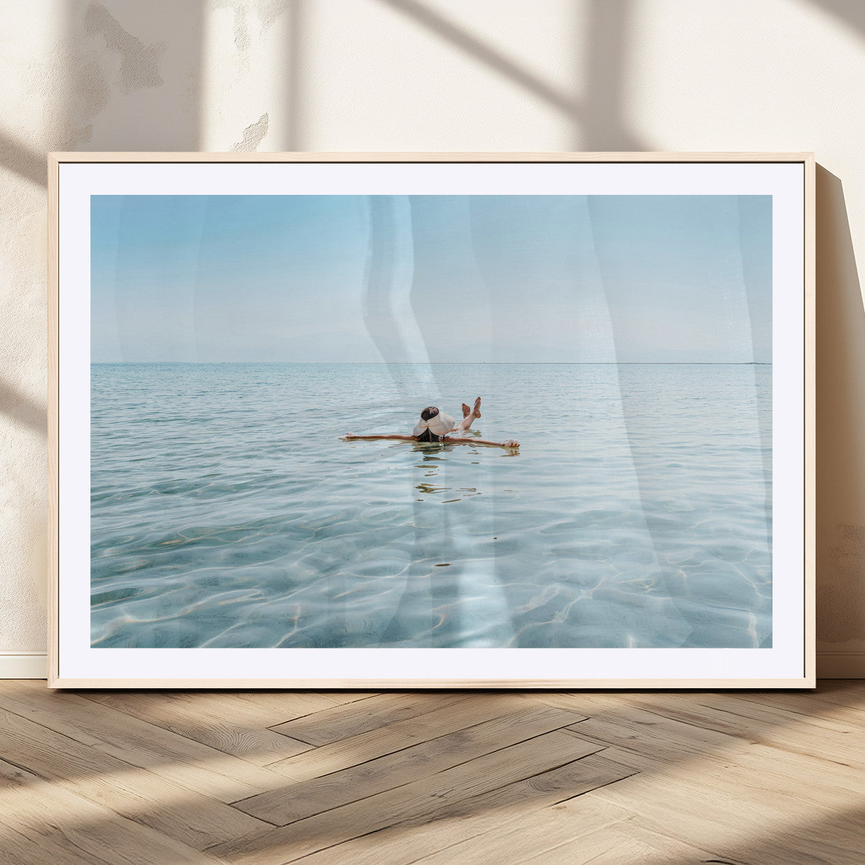 A peaceful minimalist scene of a person floating on crystal-clear water, surrounded by a vast open horizon, capturing relaxation and serenity in a tranquil aquatic setting.