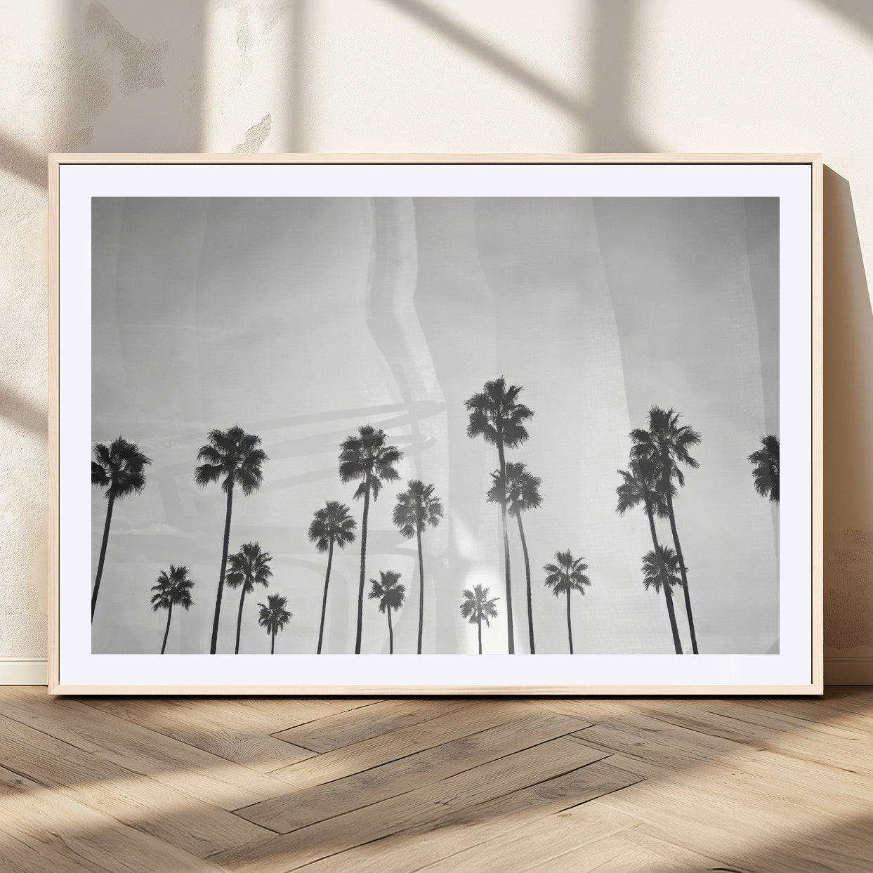 A black and white minimalist scene featuring tall palm trees silhouetted against a bright sky, creating a dreamy and timeless tropical aesthetic.