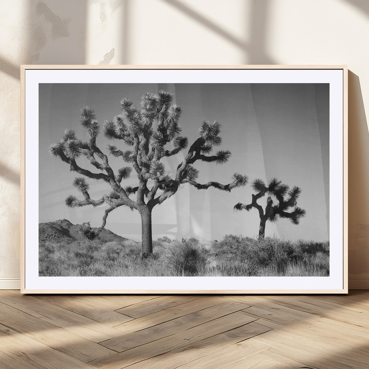 Black and white desert scene with two Joshua trees under clear sky, perfect for rustic or boho-inspired home decor.