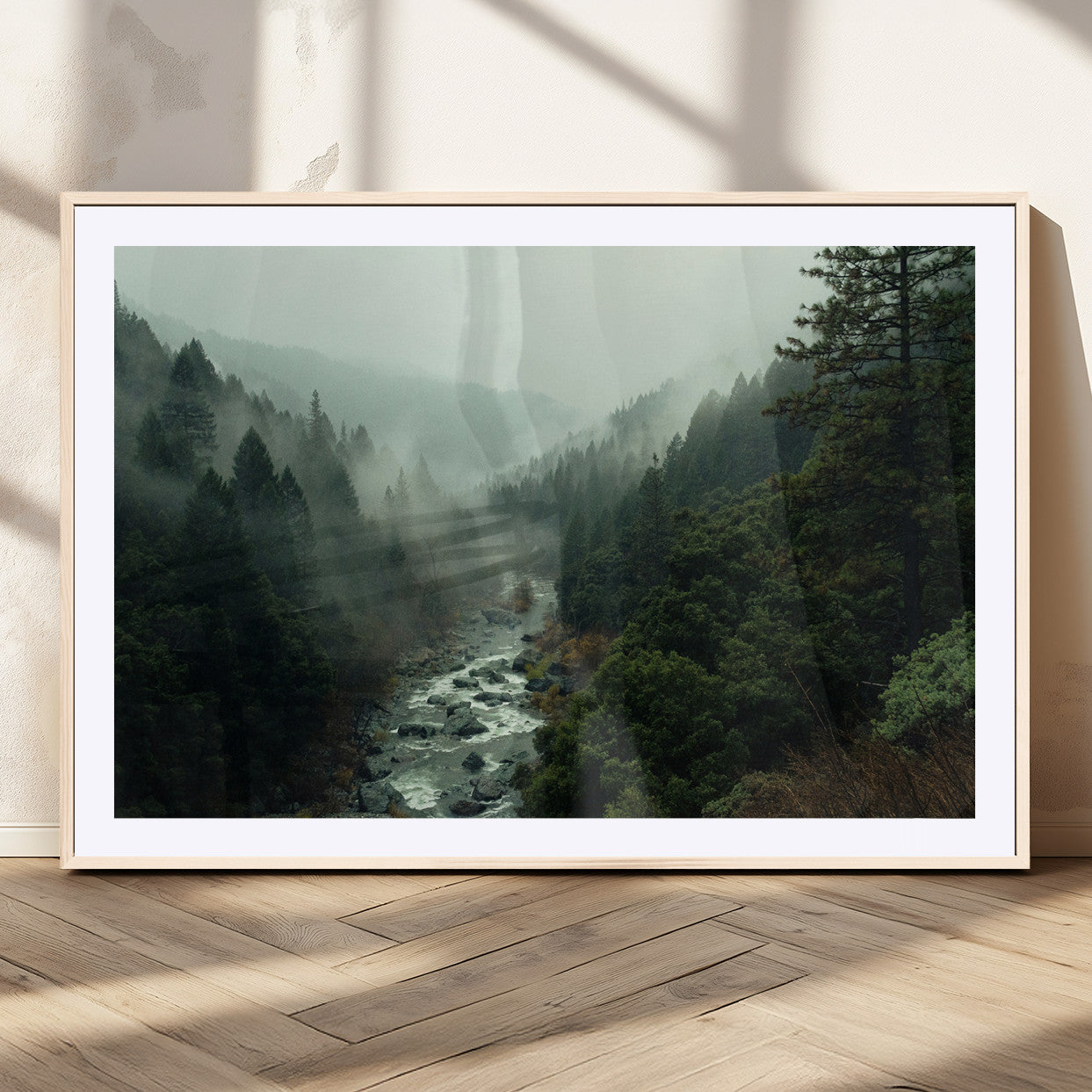 Misty forest with a winding river flowing through lush green mountains, creating a tranquil and moody wilderness landscape.