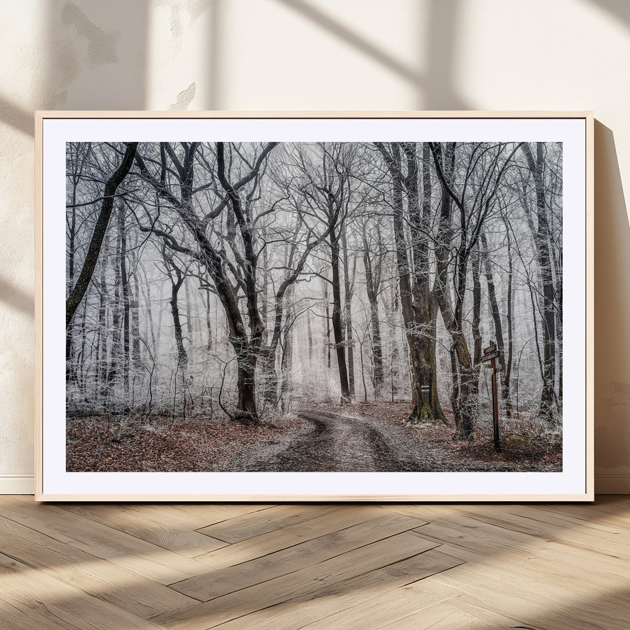 Snow-covered trees in a misty winter forest with a winding path, creating a serene and mysterious atmosphere, perfect for nature-inspired wall art.