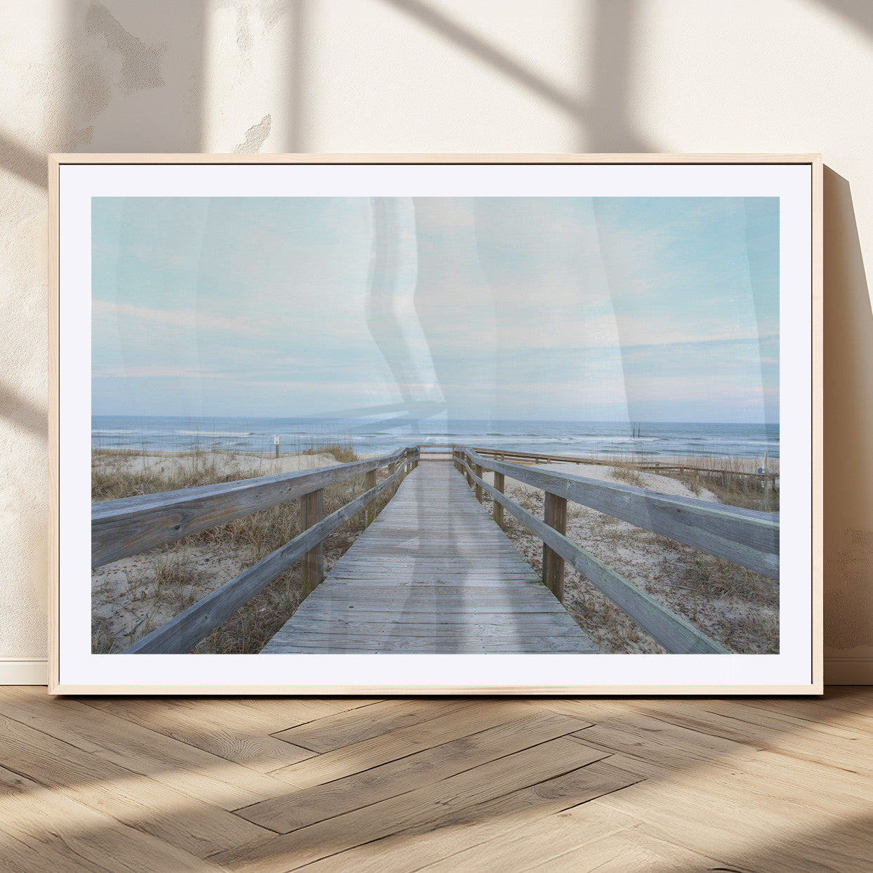 Wooden boardwalk leading to a peaceful beach with gentle ocean waves under a soft pastel sky, perfect for coastal and nautical home decor.