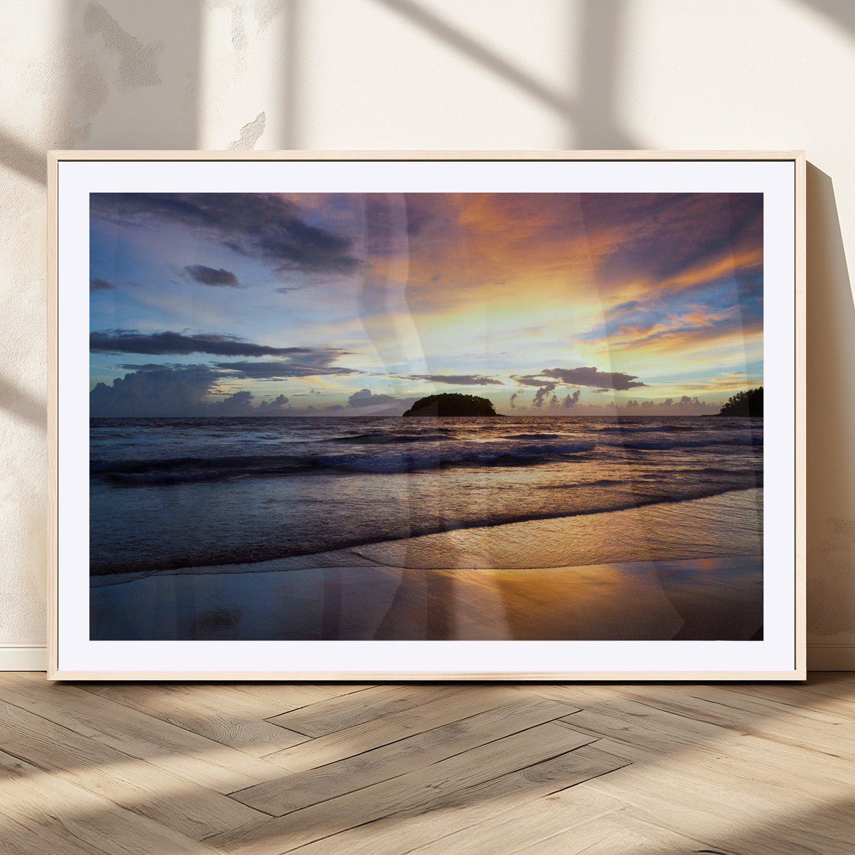 A tropical beach at sunset with waves gently washing ashore, reflecting golden and purple hues in the sky, creating a tranquil coastal scene.