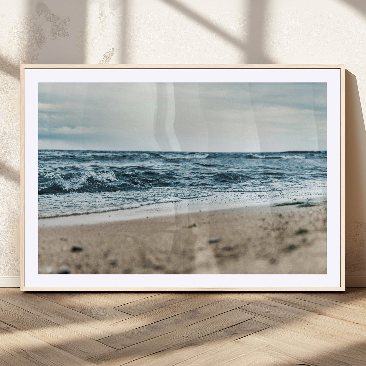 A moody ocean scene with gentle waves washing onto a sandy beach under a cloudy sky, creating a peaceful and coastal atmosphere.