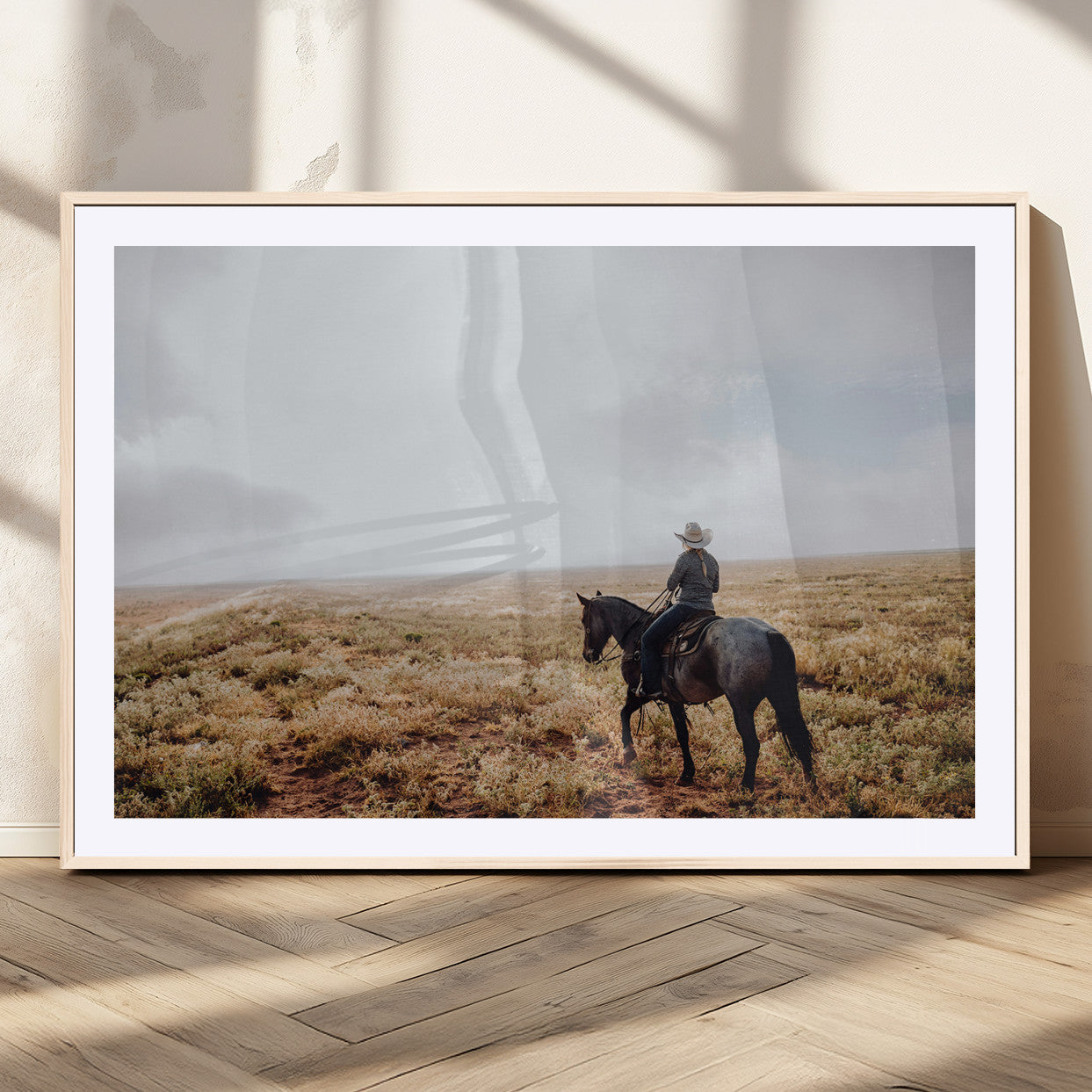 A lone cowboy riding horseback across an open prairie under a vast sky, capturing the rugged and timeless spirit of the Western frontier.