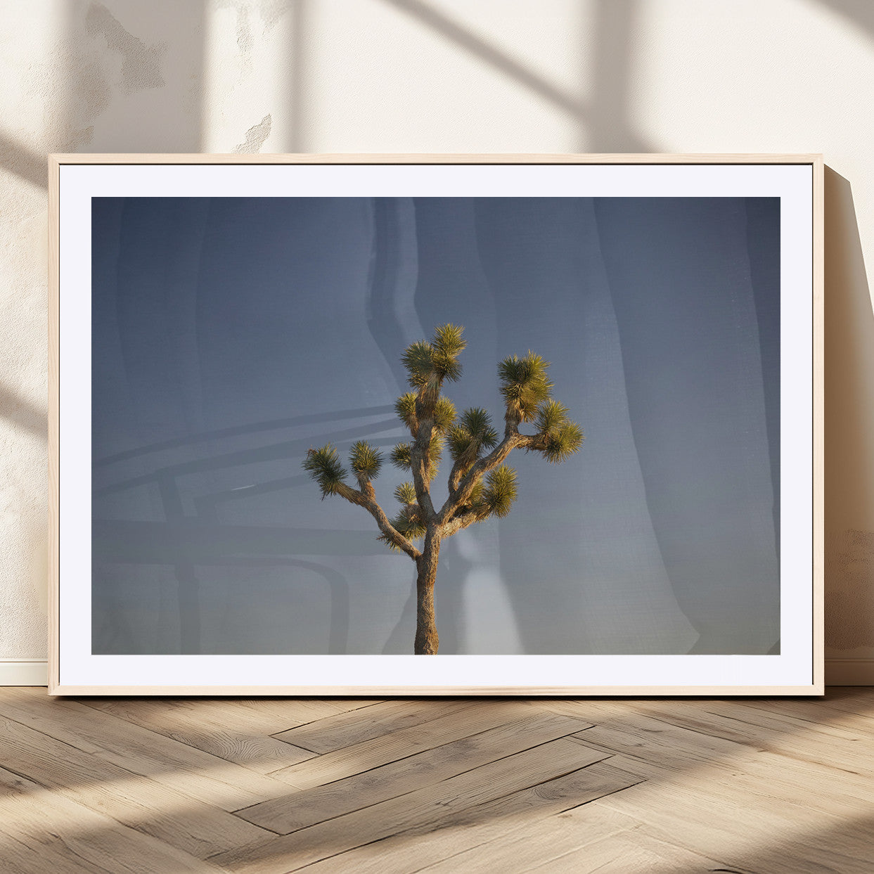 A lone Joshua Tree standing against a deep blue sky, capturing the serene and rugged beauty of the Southwestern desert landscape.