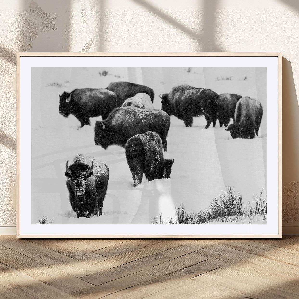 Black and white photograph of a bison herd in a snowy landscape, with snow-covered fur and a rugged wilderness setting, perfect for rustic lodge decor.