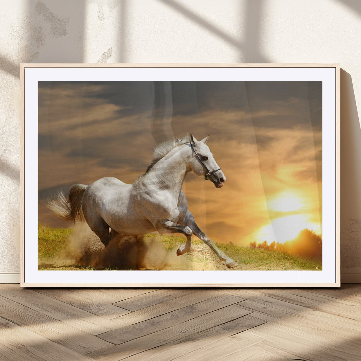 A powerful white horse galloping through the field at sunset, with the golden light illuminating its mane and the vibrant sky in the background.