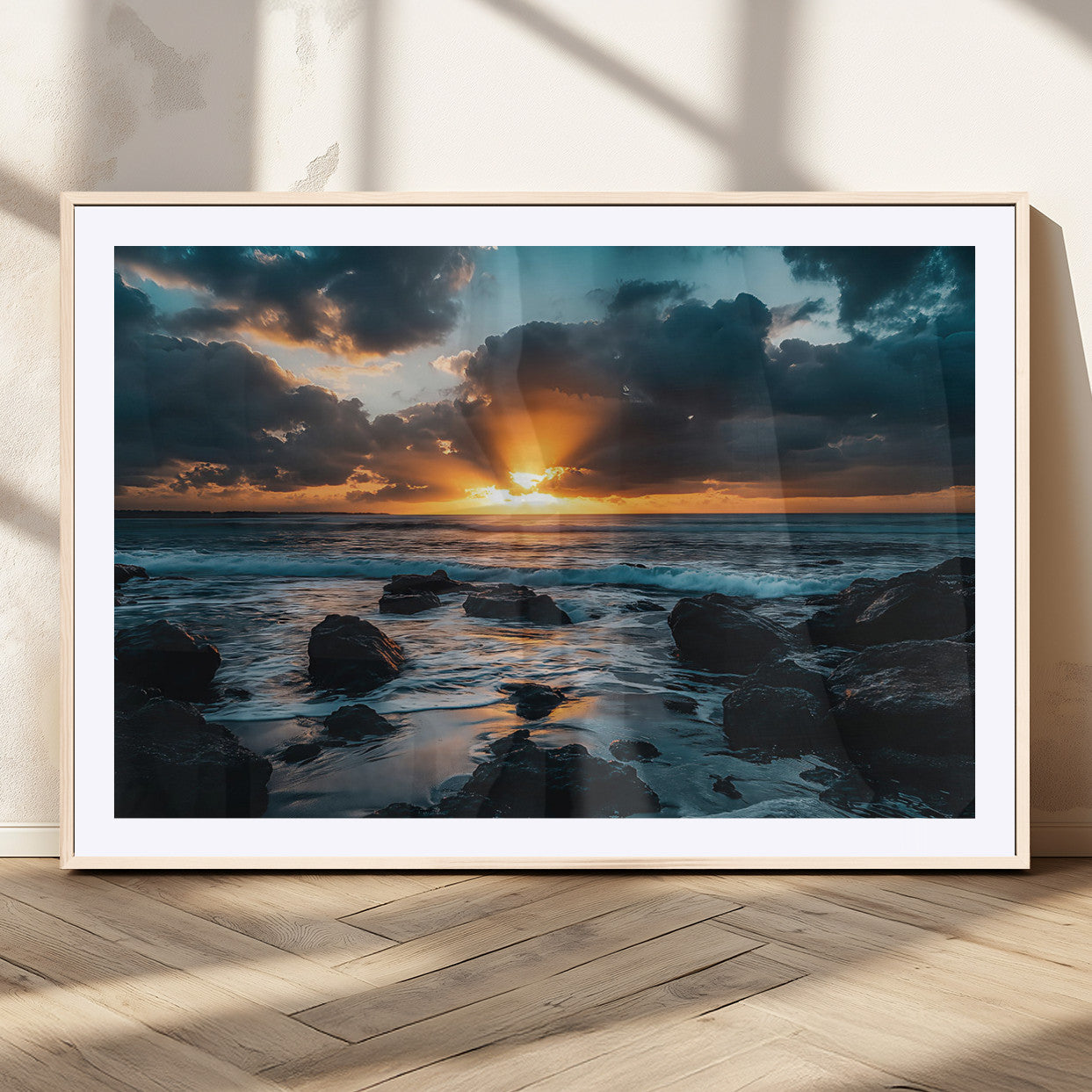 An awe-inspiring sunset over the ocean with rays of light piercing through dramatic clouds, creating a beautiful seascape with rocks in the foreground.