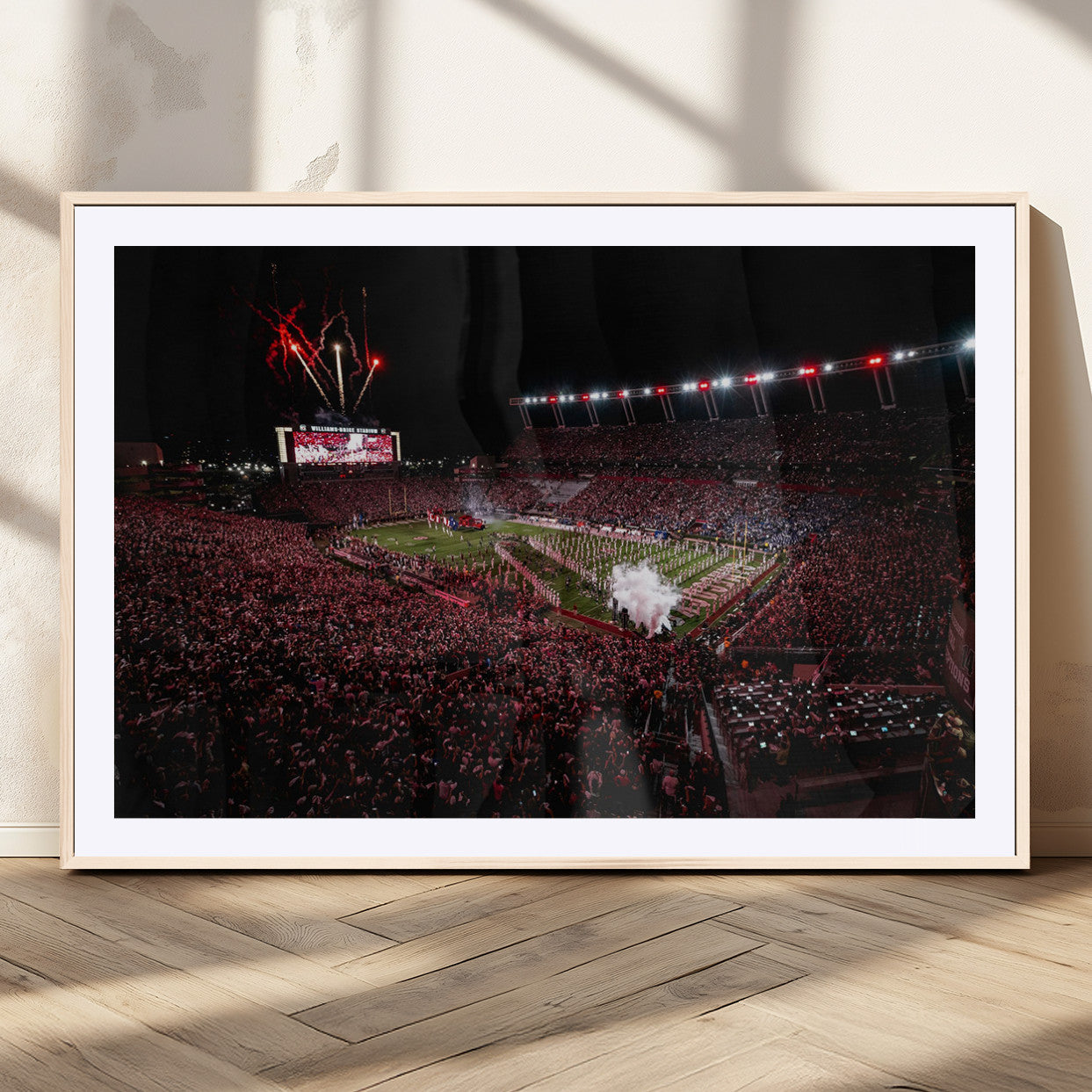A dramatic shot of a packed stadium at night, with fireworks and smoke creating an exciting atmosphere for a live football game.
