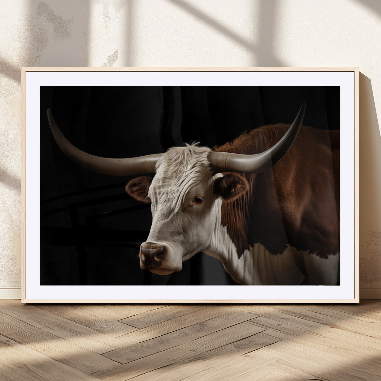 "Close-up of a brown and white longhorn cow with prominent curved horns against a black background."