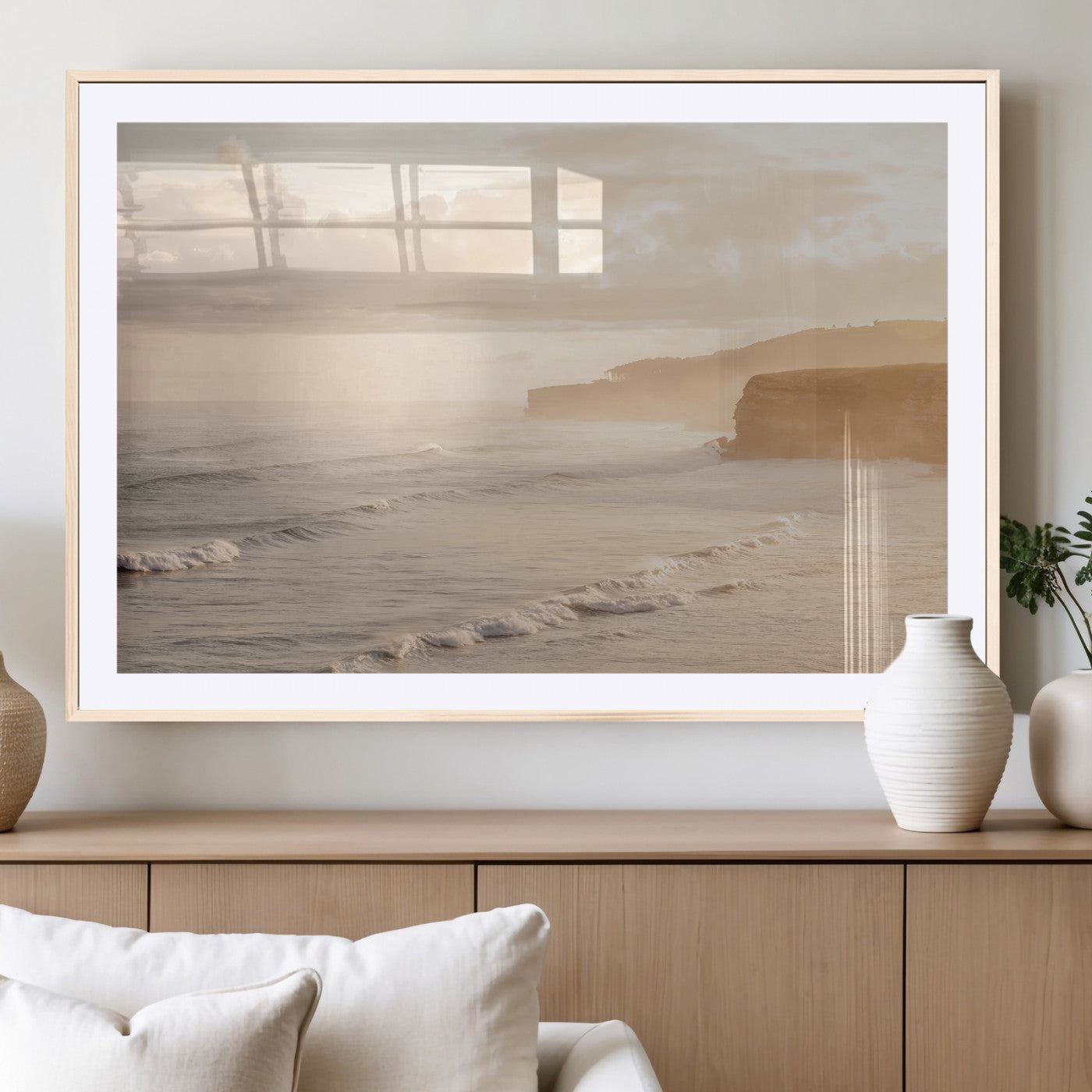 Golden hour seascape with misty cliffs and gentle waves rolling towards the shore, capturing a tranquil and warm coastal atmosphere.