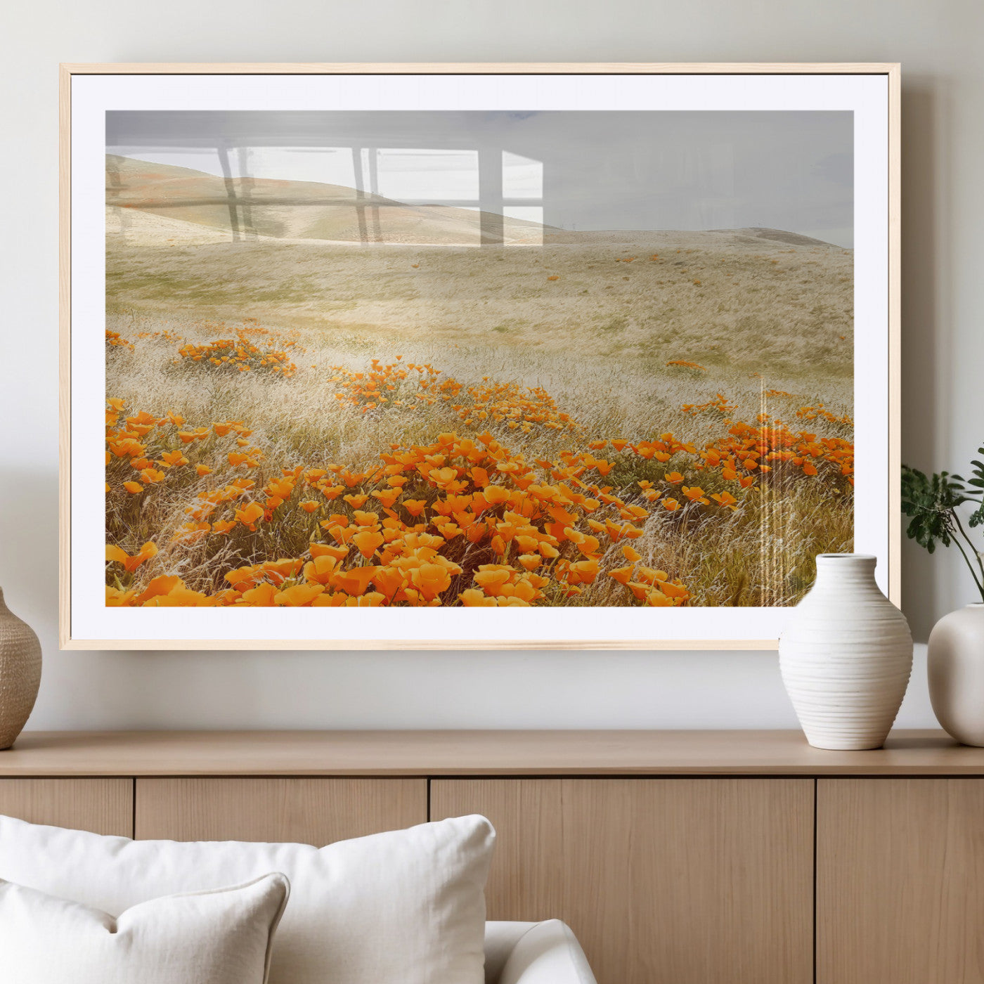 A golden field with vibrant orange poppies blooming across rolling hills under a soft, sunlit sky, creating a warm and rustic landscape.