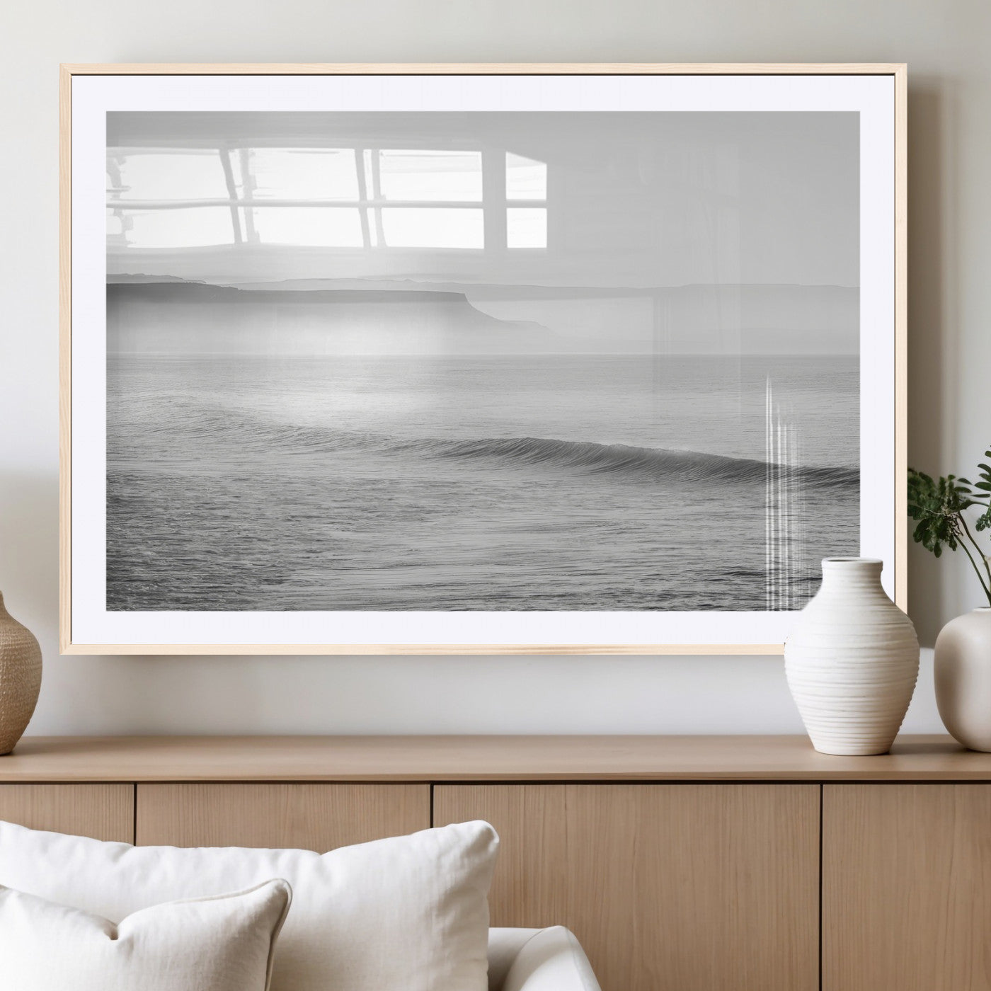 A black and white minimalist seascape featuring soft rolling waves and misty distant cliffs, creating a serene and timeless coastal atmosphere.