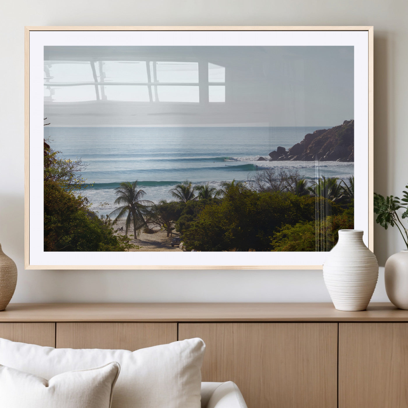 View of calm ocean waves with palm trees and a tropical coastline, ideal for coastal boho or beach-themed wall decor.