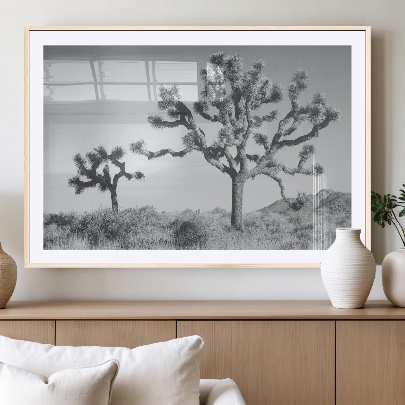 Two Joshua trees in a black and white desert landscape with distant hills, ideal for boho or rustic interior wall styling.