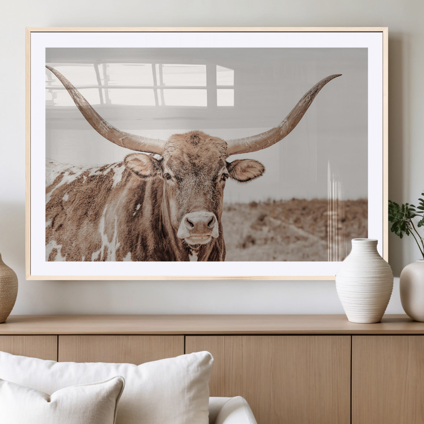 A longhorn cow in soft beige desert tones, standing calmly in open land, perfect for neutral western or rustic farmhouse interiors.